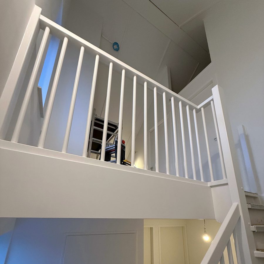 Wit geschilderde trapleuning en balustrade